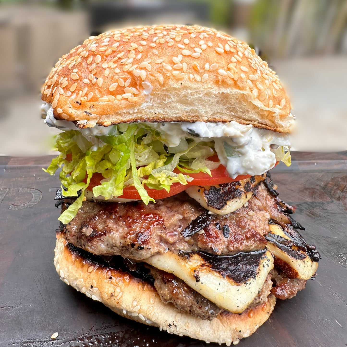 lamb burger with charred saganaki cheese, tzatziki, lettuce and tomato