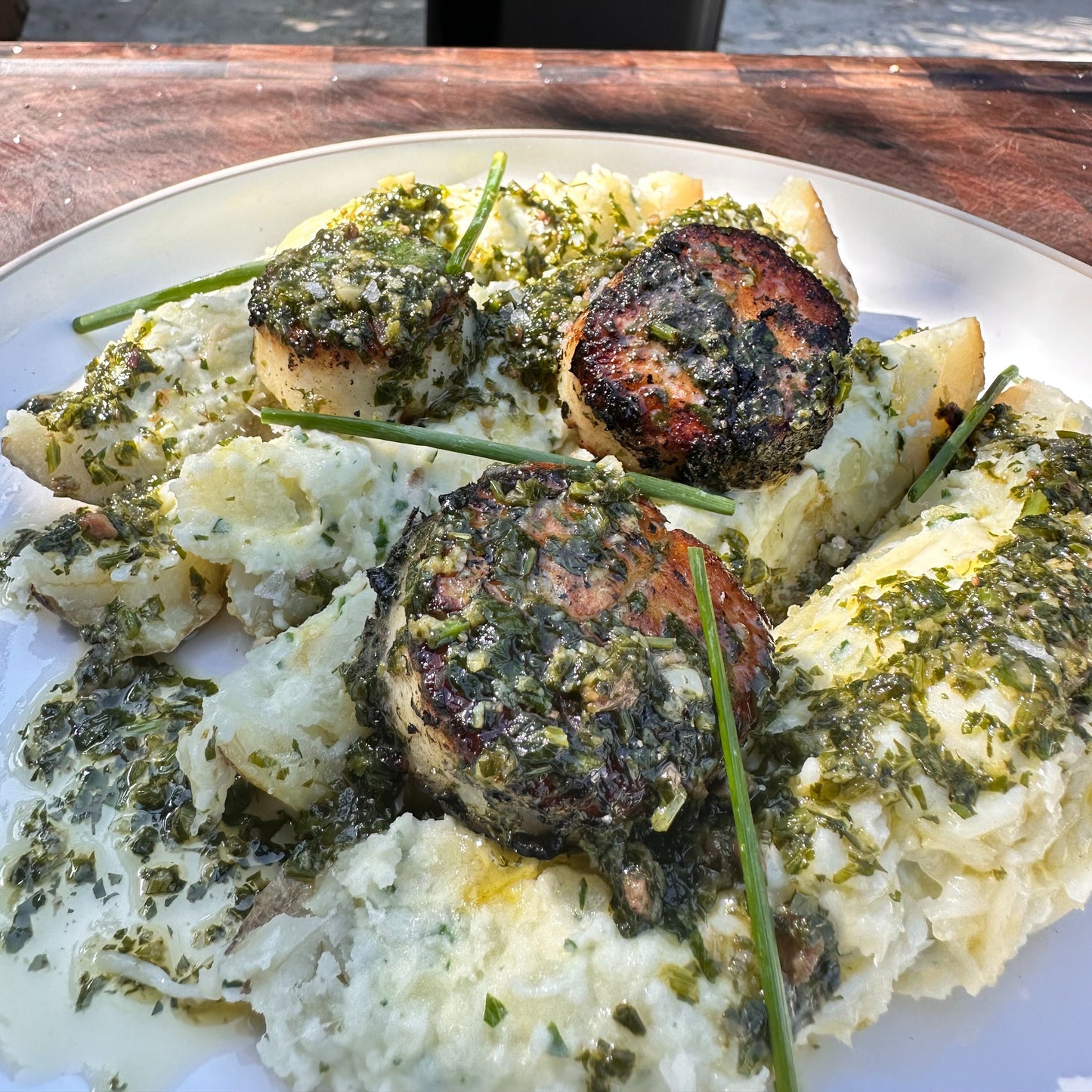 seared scallops on a loaded baked potato with anchovy garlic butter