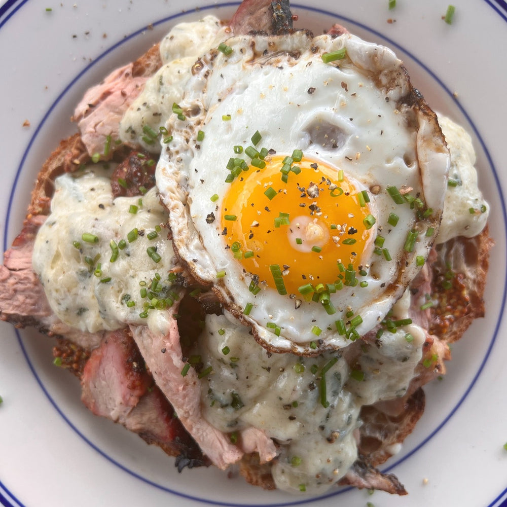 smoked pork loin croque madame with a fried sunny egg and chopped chives