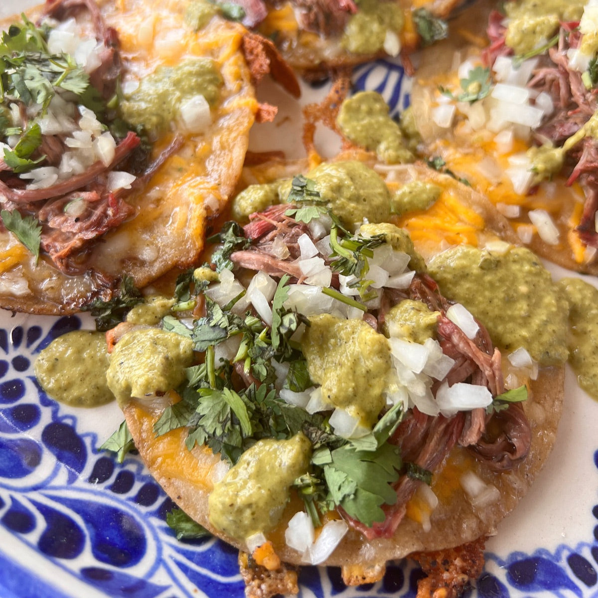 smoked birria beef tacos with cilantro, onion and green sauce