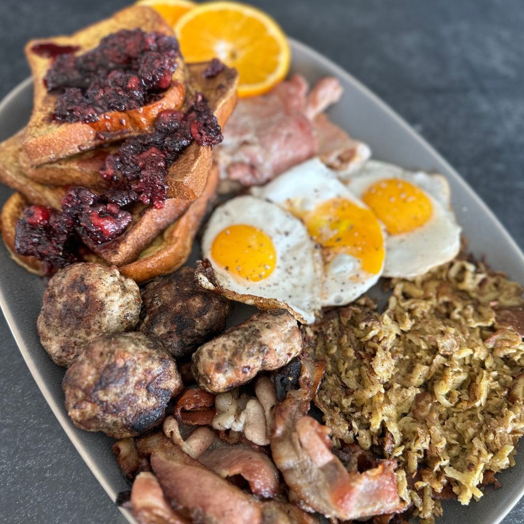 grand slam breakfast with bacon, eggs, peameal bacon, sausage, French toast with raspberry jam and hash browns
