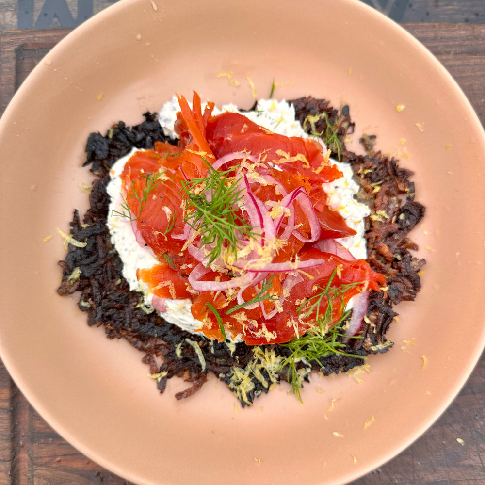 smoked salmon on a potato rosti with dill lemon cream cheese and pickled onions