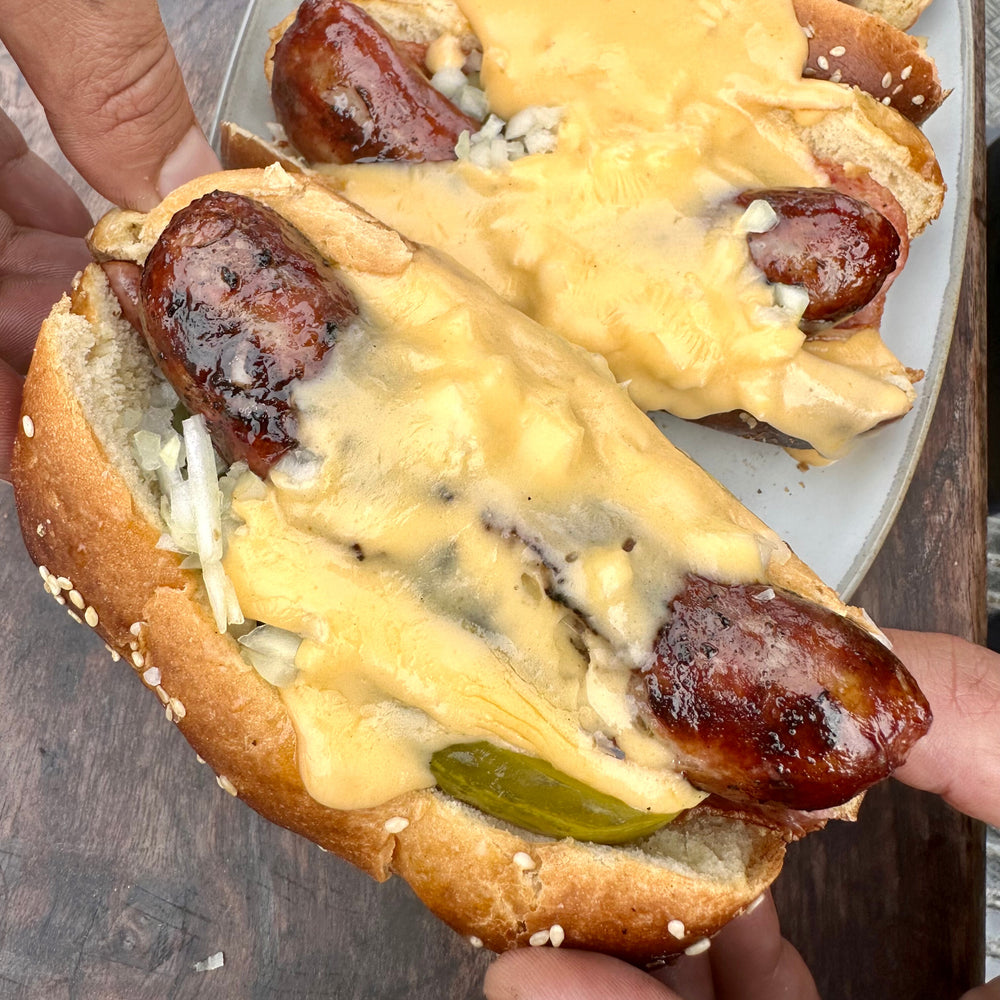 smoked bratwurst sausage in a bun with beer cheese sauce