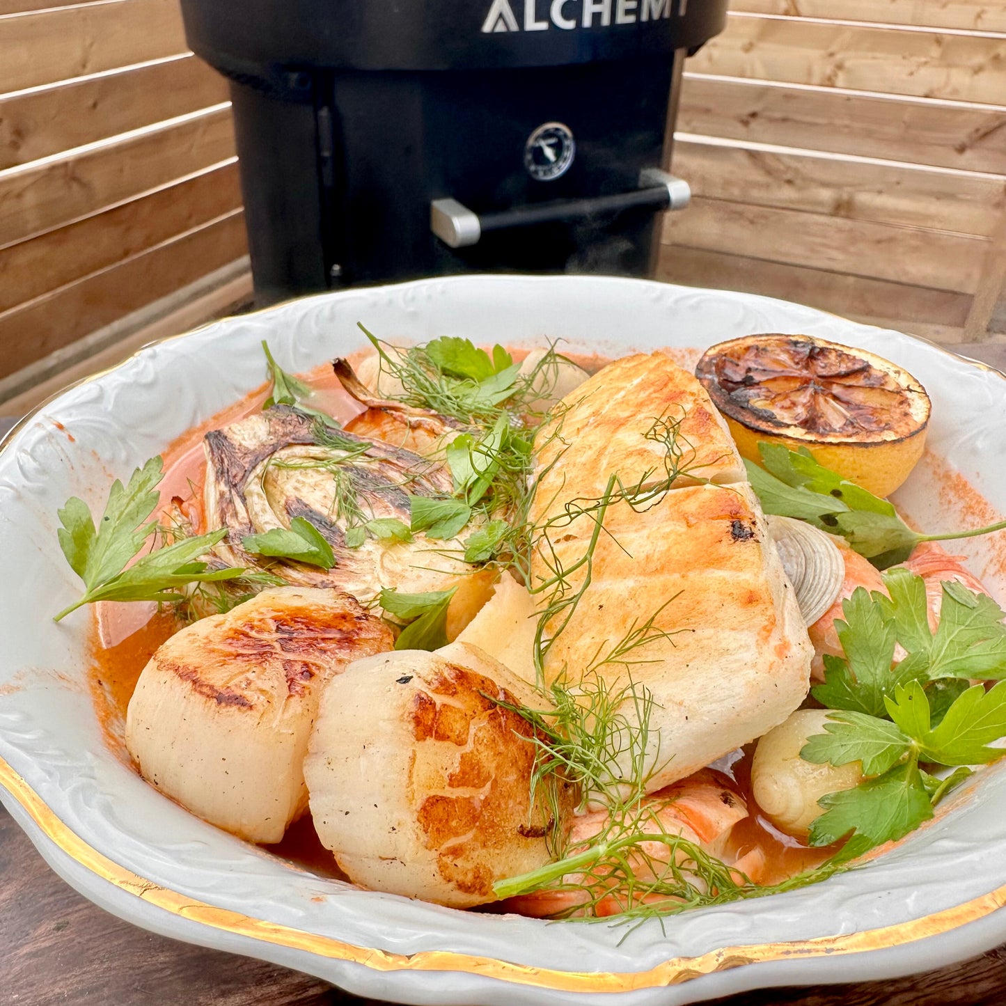 a bowl of zuppa di pesce with seared scallops, cod, shrimp, grilled fennel and Italian parsley garnish
