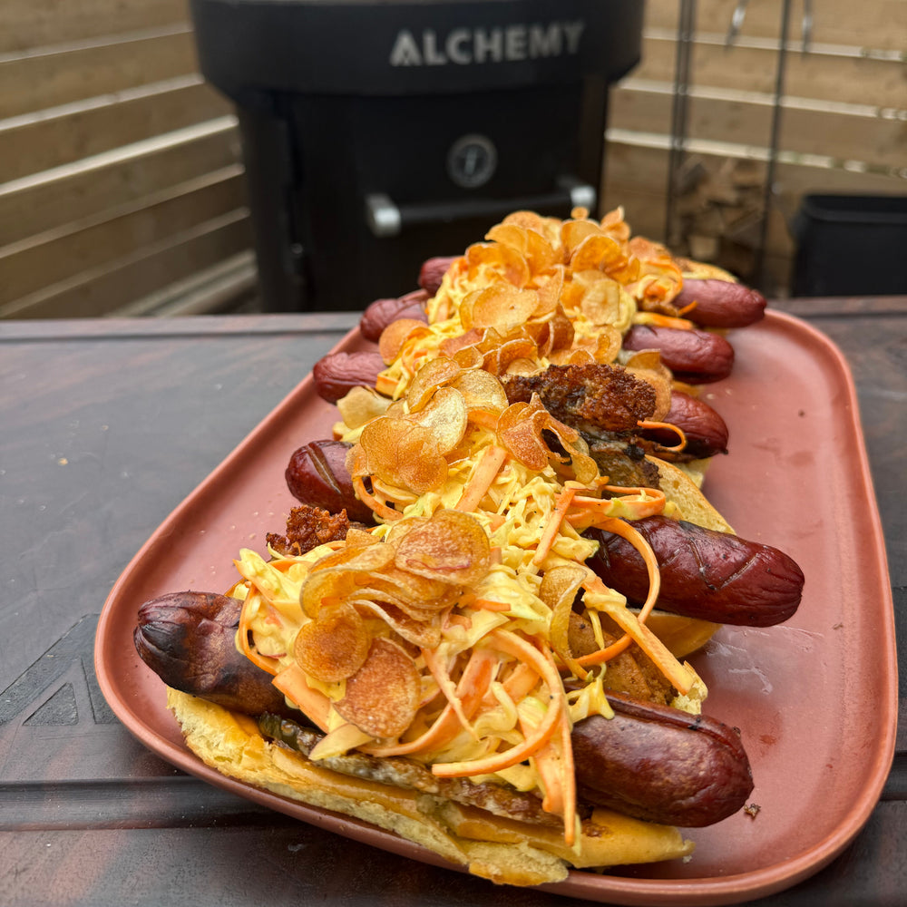 smoked hot dogs with pickle and cheese crisps, coleslaw, and mini potato chips